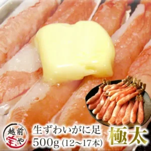 バターをのせて焼いたずわいがにの脚の調理例写真。右下に皿に並べた生のポーション、下部に「生ずわいがに足 500g(12〜17本)」「極太」の文字と越前宝やのロゴ