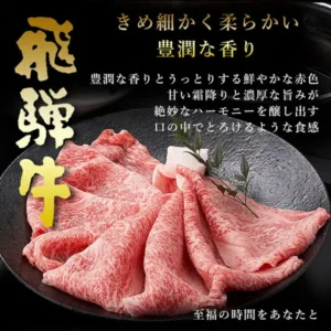 黒い丸皿に波打つように盛り付けた飛騨牛のすき焼き用薄切り肉（霜降り）のクローズアップ写真。中央に緑の葉と白い添え物が少し見える。画像内には店舗による「飛騨牛」「きめ細かく柔らかい 豊潤な香り」「豊潤な香りとうっとりする鮮やかな赤色 甘い霜降りと濃厚な旨みが絶妙なハーモニーを醸し出す 口の中でとろけるような食感」「至福の時間をあなたと」の文字がある