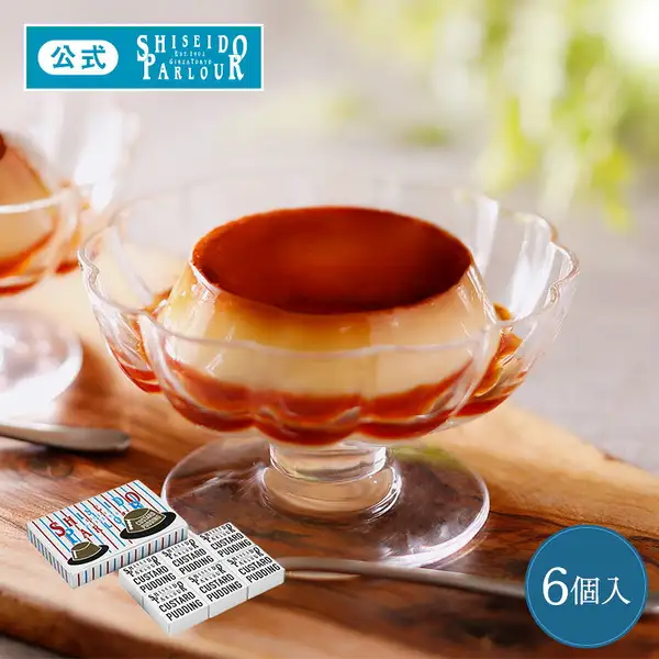 Photo of Shiseido Parlour Custard Pudding, 6 pieces: custard pudding with caramel on top and at the bottom, in a clear footed dish with a flower-shaped rim, on a wooden board. At lower left, an outer box with blue and red stripes and hat illustrations, and 6 small white boxes printed "SHISEIDO PARLOUR" and "CUSTARD PUDDING". Text the shop placed on the image: a "公式" (official) and "SHISEIDO PARLOUR Est.1902 GINZA TOKYO" logo, and "6個入" (6 pieces)