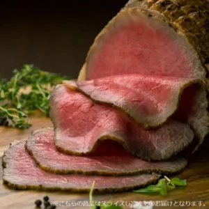 木の台の上に、表面に焼き色の付いたかたまりの肉のいとう 仙台牛ローストビーフと、そこから切り出した断面がピンク色の薄切り4枚(2枚を折り重ね、2枚を平らに重ねたもの)を、ハーブ・葉野菜・黒こしょうの粒と並べた盛り付け例の写真(ハーブ・葉野菜・黒こしょうの粒は商品に含まれない)。画像の下に店舗が画像に入れた表示「※こちらの商品はスライスし冷凍でのお届けとなります。」の文字