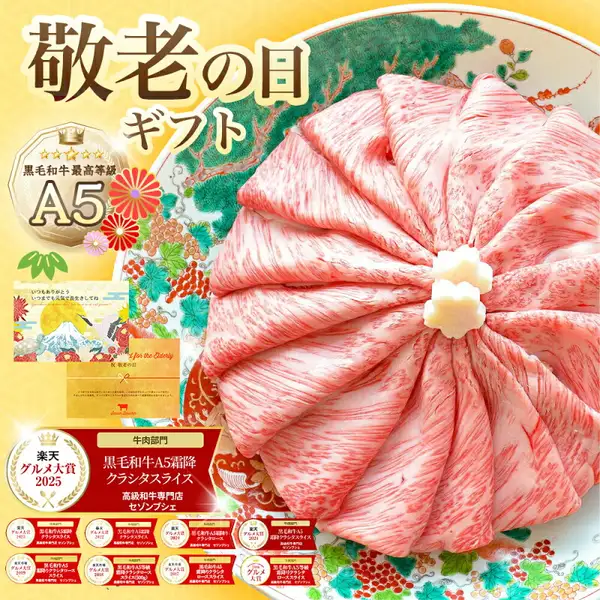 森田商店（セゾンブシェ）の黒毛和牛A5等級 霜降りクラシタロース スライス500gを、松と花柄の和皿にロゼット状に盛り付け、中央に花形の白い飾り2個を添えた商品画像。左側にメッセージカードとのし紙の見本（「いつもありがとう いつまでも元気で長生きしてね」「祝 敬老の日」の文字）を重ねている。画像内には「敬老の日ギフト」の見出し、「黒毛和牛最高等級A5」のバッジ、「楽天グルメ大賞2025」と2016〜2020年・2022〜2024年分（計9個）の受賞バッジ、「牛肉部門 黒毛和牛A5霜降クラシタスライス 高級和牛専門店セゾンブシェ」の表示があります。