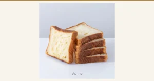 京都祇園ボロニヤ 元祖デニッシュ食パン 1斤スライス3個の記事アイキャッチ。商品写真。白い台の上に、5枚にスライスされたプレーンのデニッシュ食パンが置かれている。1枚は手前に立てかけられ、残りの4枚は奥に重ねてある。断面は白っぽく、耳は濃い焼き色。店舗が画像に入れた表示「プレーン」