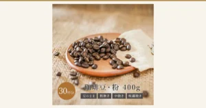 Photo of dark-roast coffee beans heaped on a wooden plate set on a linen cloth. Text the shop placed in the image, at the bottom: “30杯分” (30 cups), “珈琲豆・粉 400g” (coffee beans / ground, 400g), “豆のまま” (whole beans), “粗挽き” (coarse grind), “中挽き” (medium grind) and “極細挽き” (extra-fine grind).