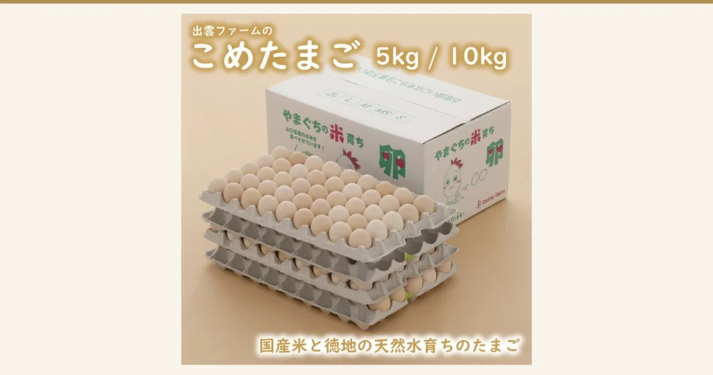 Product photo of 出雲ファーム こめたまご eggs. Four gray paper egg trays are stacked in front of a white cardboard box with a chicken character drawn on it; the top tray holds neatly lined-up pale beige eggs. Text the store placed in the image: “出雲ファームの こめたまご”, “5kg / 10kg”, “国産米と徳地の天然水育ちのたまご”, “やまぐちの米育ち”, “山口県産のお米を食べさせています！”, “izumo farm”