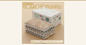 出雲ファームのこめたまごの商品写真。白い段ボール箱の手前に、卵を並べた灰色の紙製トレーが4段重ねて置かれ、一番上のトレーにはうすいベージュ色の卵が整然と並んでいる。箱にはニワトリのキャラクターの絵がある。店舗が画像に入れた表示：「出雲ファームの こめたまご」「5kg / 10kg」「国産米と徳地の天然水育ちのたまご」「やまぐちの米育ち」「山口県産のお米を食べさせています！」「izumo farm」
