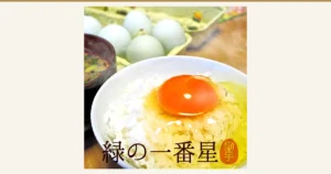 Photo of 緑の一番星 Raw Eggs, 30-Count (田子たまご村): a raw egg yolk on rice with a bowl of miso soup, and pale green-shelled eggs in a tray behind. Text the store added to the image: “緑の一番星”. The rice and miso soup are not included in the product