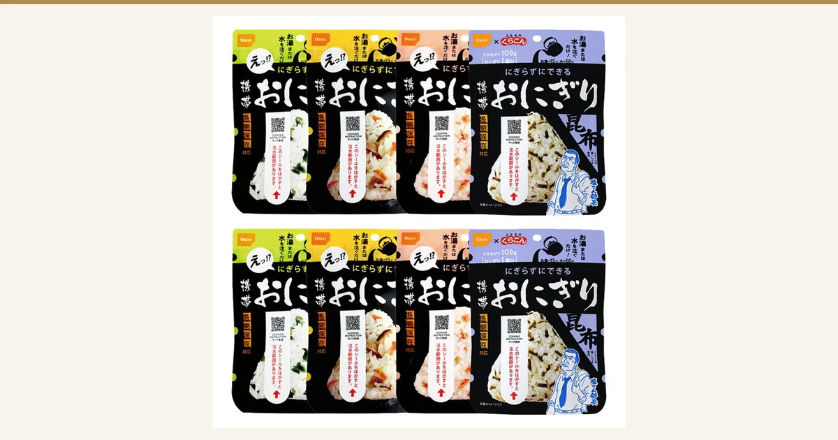 尾西食品 携帯おにぎり8食分（五目・昆布・鮭・わかめ各2個）の商品写真。黒地の袋が上下2段に4袋ずつ、計8袋並んでいる。左から わかめ・五目・鮭・昆布の袋で、袋に印刷された表示「携帯おにぎり」「にぎらずにできる」「長期保存対応」「写真はイメージです」