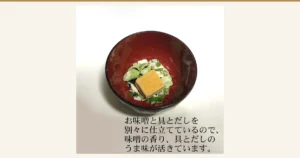 しま村のフリーズドライ だし香る味噌汁 10食のアイキャッチ。赤い椀に入った、お湯を注ぐ前のフリーズドライの味噌のかたまりと、ねぎなどの具の写真。店舗が画像に入れた表示「お味噌と具とだしを別々に仕立てているので、味噌の香り、具とだしのうま味が活きています。」