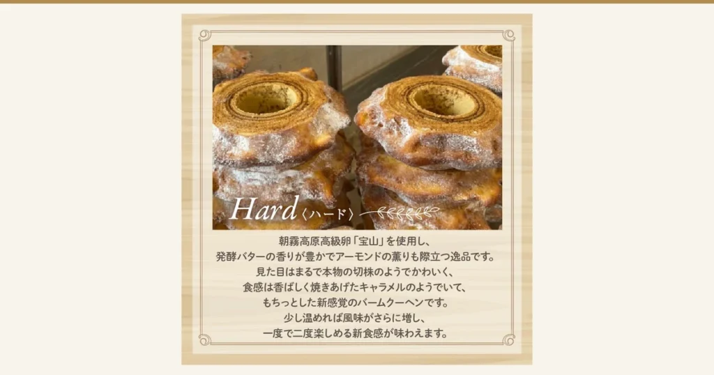 故乡纳税回礼品「ばあむくん かため」的商品页面图片。外形像树桩、中间有孔的年轮蛋糕（バウムクーヘン）层层叠起，形成两堆，左右并排。左下角有手写体的「Hard」和「〈ハード〉」（硬质）字样。店铺自行加入图片的文字：「Hard〈ハード〉」（硬质）「朝霧高原高級卵『宝山』を使用し、発酵バターの香りが豊かでアーモンドの薫りも際立つ逸品です。見た目はまるで本物の切株のようでかわいく、食感は香ばしく焼きあげたキャラメルのようでいて、もちっとした新感覚のバームクーヘンです。少し温めれば風味がさらに増し、一度で二度楽しめる新食感が味わえます。」（销售文案：使用朝雾高原的高级鸡蛋“宝山”，发酵黄油的香气浓郁，杏仁的香味也很突出；外形酷似真正的树桩，十分可爱；口感像烤得香脆的焦糖，却又软糯有嚼劲，是全新感觉的年轮蛋糕；稍微加热会让风味更浓，一次就能享受两种口感）。