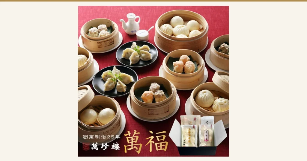 Product photo of the 萬珍樓 萬福 Dim Sum Assortment, 6 Types (34 Pieces): shumai, boiled dumplings, pork buns and sweet red bean buns served in steamer baskets and on a plate, with a gift set in a black box, arranged against a red background. Text the shop placed in the image: “創業明治25年”, “萬珍樓”, “萬福”