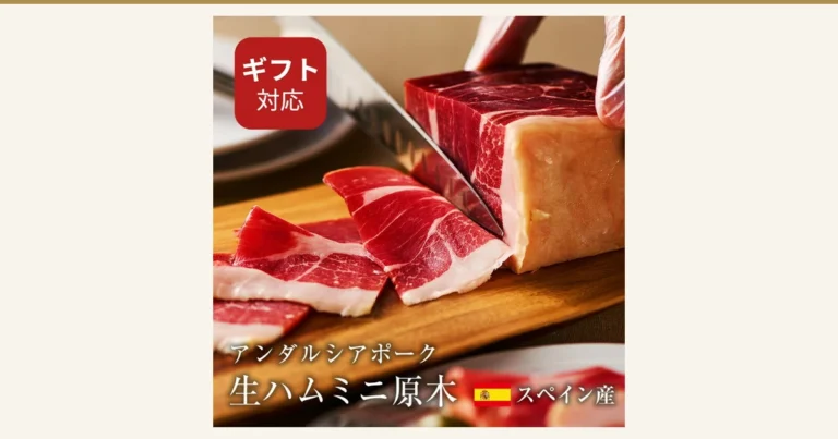 Featured image of the raw ham mini genboku (Andalusian pork): a product photo of a block of raw ham being cut with a knife on a wooden board, with thin slices laid out in front. Text the shop put into the image: “ギフト対応” (gift-ready), “アンダルシアポーク 生ハムミニ原木” (Andalusian pork raw ham mini genboku), “スペイン産” (from Spain).