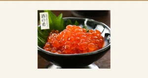 盛在黑色高脚碗中的鳟鱼子酱油渍商品照片，碗里垫着绿色紫苏叶。店铺放入图片的文字：「酒の肴」（下酒菜）、「お酒が進みます♪」（让人越喝越想喝酒）。