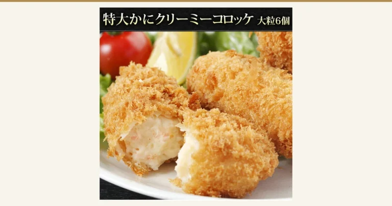 Featured image for Uoko Crab Cream Croquettes, 6 Large Pieces: a product photo of fried croquettes served on a plate, one broken open to show the white cream filling. The lemon, cherry tomato and lettuce are a serving suggestion and are not included in the product. Text the shop placed in the image: “特大かにクリーミーコロッケ 大粒6個” (extra-large crab creamy croquettes, 6 large pieces).