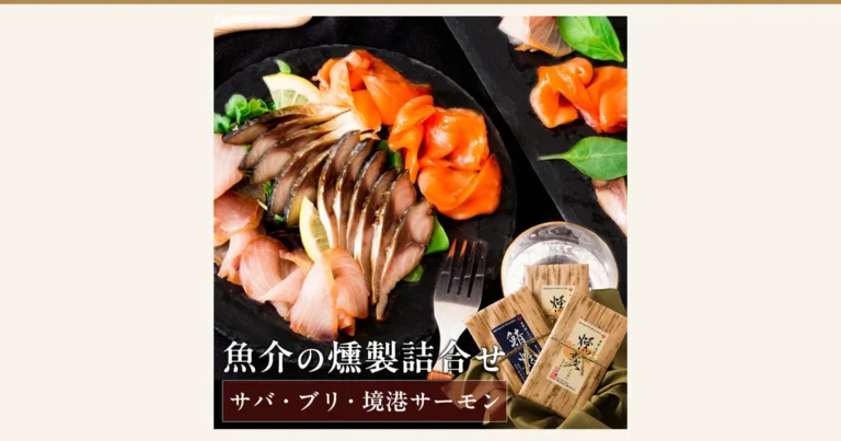 サバ・ブリ・境港サーモンの燻製の薄切りをレモンと葉物とともに黒い皿に盛り付け、フォークとグラス、木目調の包装の商品3袋を添えた商品写真（風味絶佳.山陰 魔法のスモーク 魚介の燻製詰合せ）。店舗が画像に入れた表示「魚介の燻製詰合せ」「サバ・ブリ・境港サーモン」