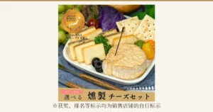 盘中摆放的熏制奶酪（煙神可选熏制奶酪组合装）商品照片，可见撒有黑胡椒的长方形奶酪、熏制奶酪和切开的卡蒙贝尔类奶酪。盘中还摆有饼干、葡萄、橄榄、小番茄、欧芹和紫甘蓝，这些是装盘示例，不包含在商品中。店铺在图片中加入的标示：“JAPAN FOOD SELECTION”“2024年5月 グランプリ受賞”“ギフト対応”“選べる 燻製チーズセット”。下方有“※获奖、排名等标示均为销售店铺的自行标示”