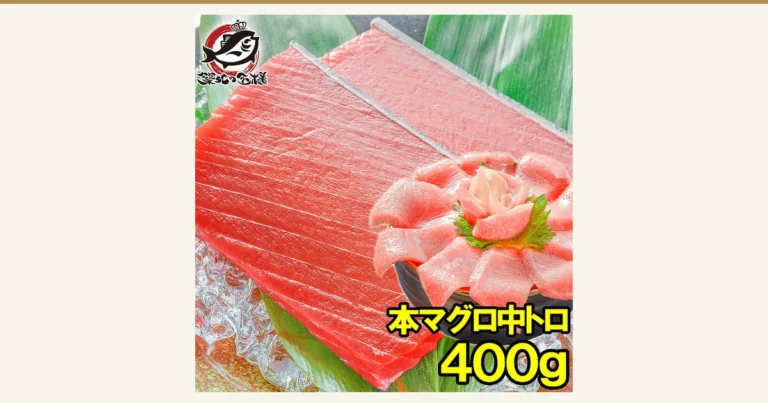築地の王様 極上 本まぐろ 中トロ 400gの商品写真。氷と笹の葉の上に赤い中トロのサクを2つ並べ、右下に中トロの切り身をしそとしょうがを添えて花のように丼へ盛り付けた様子。丼の盛り付けは盛り付け例で、しょうが・大葉・丼は商品に含まれない。店舗が画像に入れた表示「本マグロ中トロ」「400g」(左上に店舗ロゴ「築地の王様」)