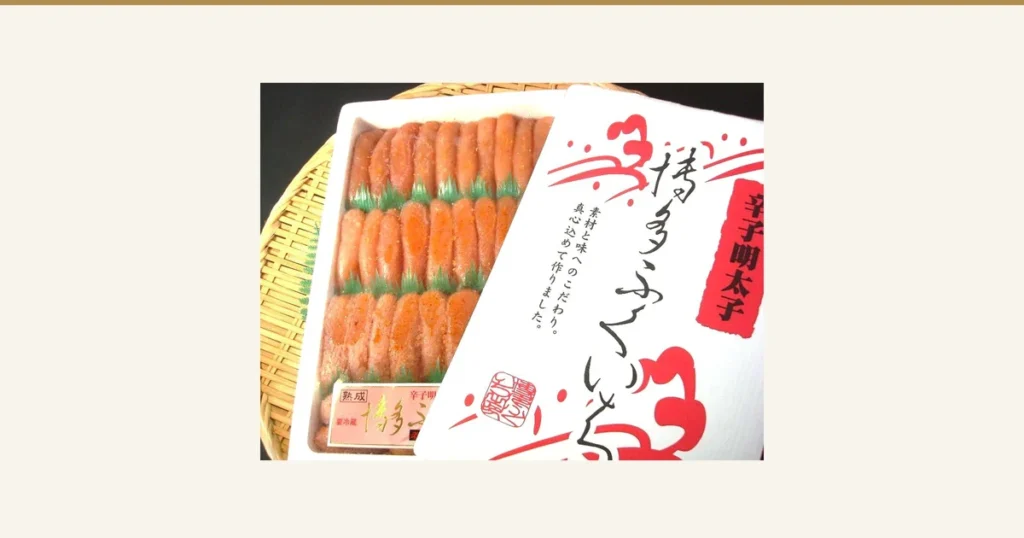 築地丸中 特上博多ふくいち粒々辛子明太子1kgの商品写真。白い容器に入った橙がかった桃色の辛子明太子が、緑の仕切りをはさんで3段に並び、容器の右側に包装のふたが重ねてある。ふたの印字は「辛子明太子」「博多ふくいち」「素材と味へのこだわり。真心込めて作りました。」と読める。