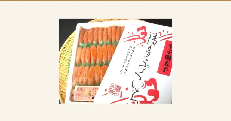 築地丸中 特上博多ふくいち粒々辛子明太子1kgの商品写真。白い容器に入った橙がかった桃色の辛子明太子が、緑の仕切りをはさんで3段に並び、容器の右側に包装のふたが重ねてある。ふたの印字は「辛子明太子」「博多ふくいち」「素材と味へのこだわり。真心込めて作りました。」と読める。