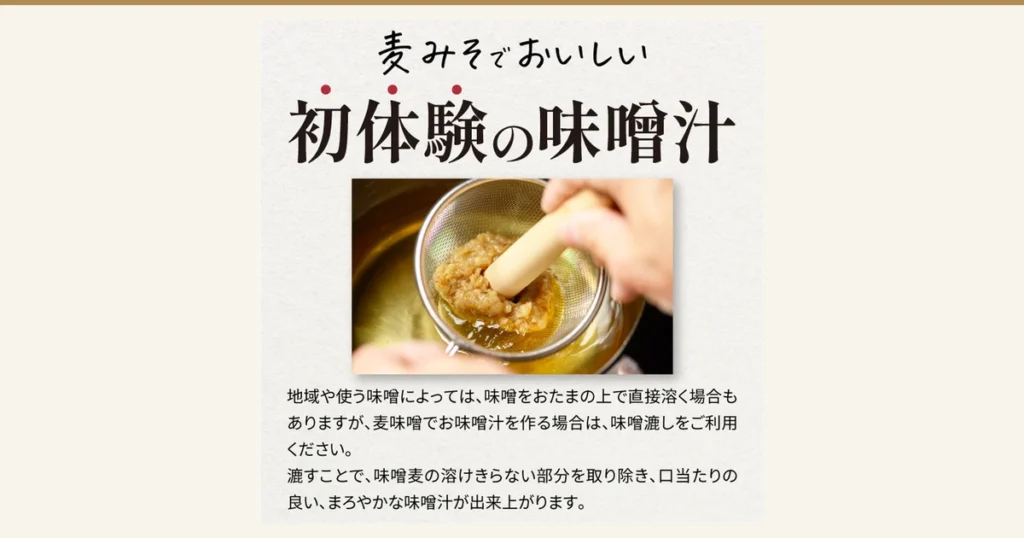At the top, “麦みそでおいしい” and “初体験の味噌汁” are written in large letters; in the photo in the middle, a hand uses a wooden pestle to press barley miso through a metal miso strainer, dissolving it into the pot below. Under the photo it says “地域や使う味噌によっては、味噌をおたまの上で直接溶く場合もありますが、麦味噌でお味噌汁を作る場合は、味噌漉しをご利用ください。” and “漉すことで、味噌麦の溶けきらない部分を取り除き、口当たりの良い、まろやかな味噌汁が出来上がります。” (text the shop placed in the image). 麦みそや Barley Miso, Sweet-Style, 500g×5 (味噌の通販 麦みそや)