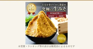 山盛りにした黄色い生味噌を黒い鉢に盛り、右に国産大豆を入れた升を置いた、やまさ味噌こうじ店 蔵出し生味噌 800gの商品写真。店舗が画像に入れた表示：「注文を受けてから袋詰め」「究極の生みそ」「ランキング第1位」「国産最高等級大豆」「国内産米」「国産塩」「800g」。下に「※受賞・ランキング等の表示は販売店によるものです」