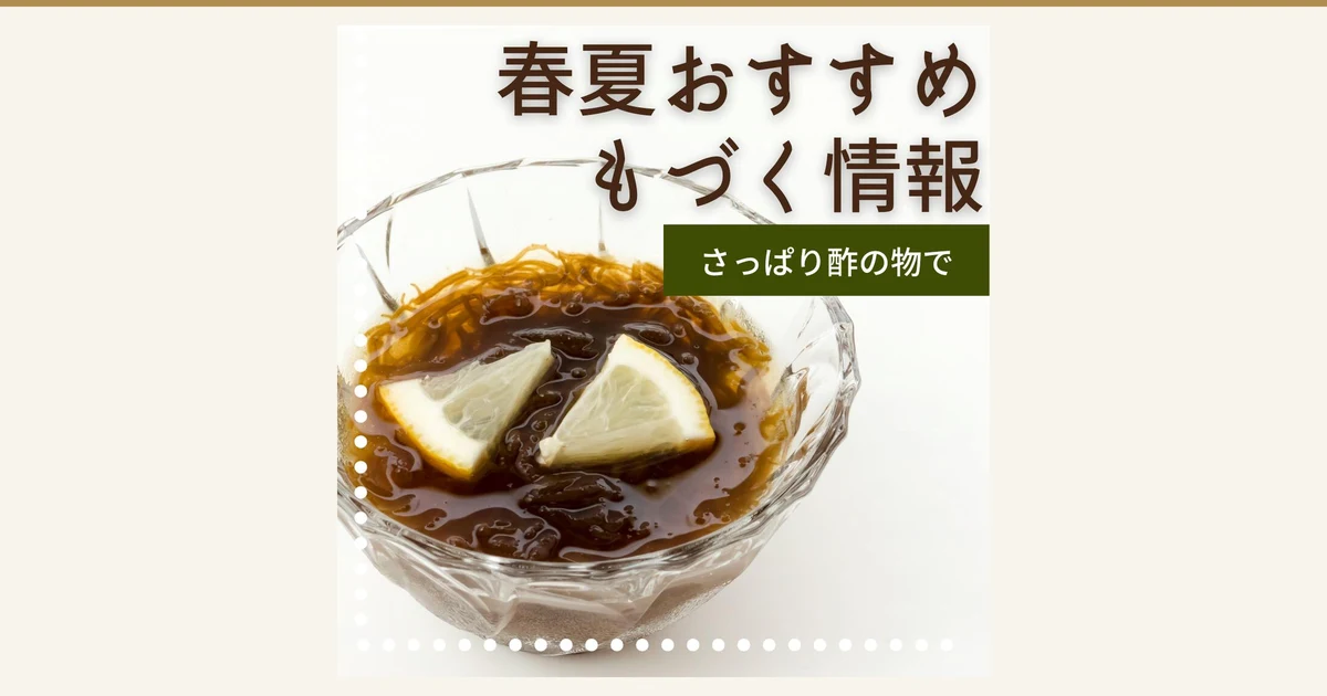 Serving-example photo for 仙崎海産 Okinawa-Grown 生太もずく (Thick Mozuku Seaweed) 1kg: amber-to-brown mozuku in dark brown liquid in a clear glass bowl, topped with two lemon wedges. Text the shop placed in the image: “春夏おすすめ もづく情報” and “さっぱり酢の物で”. The vinegar dressing and the lemon are not included with the product