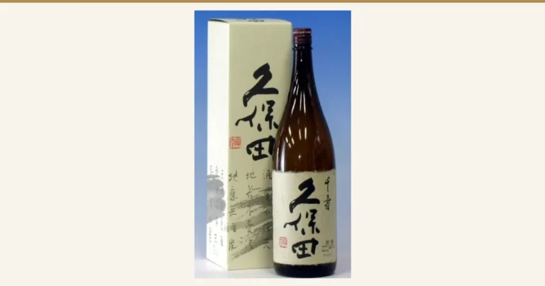 封面图。久保田 千寿 吟醸 1800ml的商品照片。蓝色背景左侧是印有「久保田」字样和红色方印的淡黄绿奶油色盒子，右侧立着一只茶色一升瓶。酒瓶的和纸风格标签上可见「千寿」「久保田」「清酒」字样和红色方印