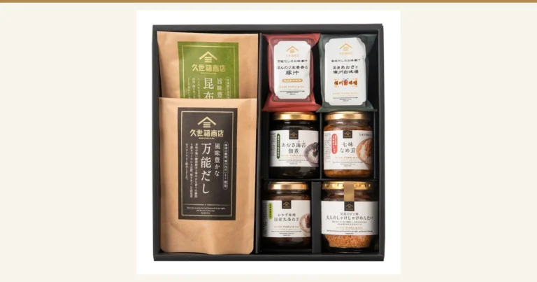 封面图。久世福商店 ごはんのお供(拌饭小菜)ギフト(附礼盒包装・8件套装)的商品照片。黑色礼盒中摆放着昆布高汤和万能高汤的纸袋2个、猪肉味噌汤和青海苔味噌汤的独立包装2个,以及青海苔佃煮、七味滑菇、下饭味噌、鲑鱼明太子碎的玻璃瓶4个,共8件。商品包装上印有「久世福商店」「国産具材使用」等文字。