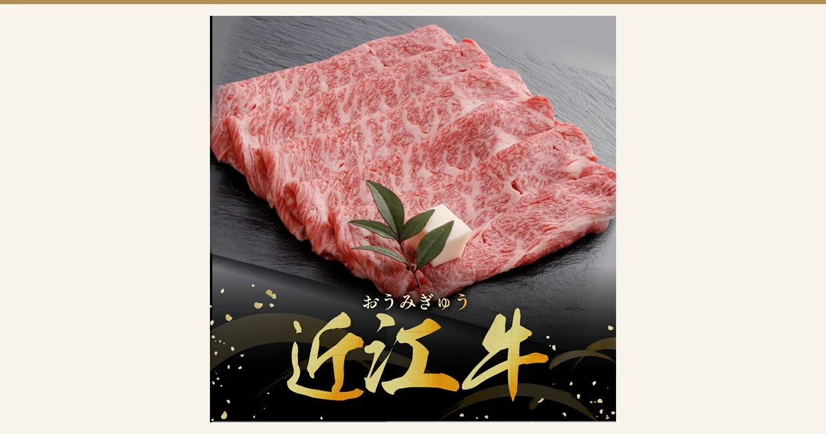 黒い石板の上に霜降りの牛肩ロースの薄切り肉を重ねて並べ、飾りの葉と白い飾りが添えられた商品写真（千成亭 近江牛 肩ロース スライス すき焼き用 500g）。店舗が画像に入れた表示として「おうみぎゅう」「近江牛」の文字