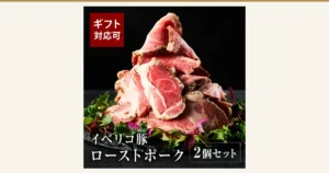 薄切りにしたイベリコ豚ローストポークを葉野菜とともに黒い石の皿に重ねた盛り付け例の商品写真（イベリコ屋 イベリコ豚 ローストポーク 280g×2個 化粧箱入り）。葉野菜は商品に含まれません。店舗が画像に入れた表示「ギフト対応可」「イベリコ豚 ローストポーク」「2個セット」