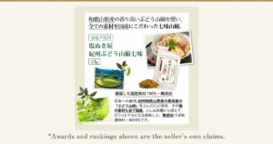 A product description image on an off-white mat showing a white 13g bag of Kishu budo sansho shichimi, the shichimi powder, a bowl of udon topped with kamaboko (fish cake) and fried tofu, terraced fields where sansho is grown, and sansho berries and leaves (one of the items included in the Reduced-Salt Seasoning Trial Set, 7 Items). Text the shop placed in the image: “和歌山県産の香り高いぶどう山椒を使い、全ての素材を国産にこだわった七味山椒。” (shichimi sansho made with fragrant budo sansho from Wakayama Prefecture, with all ingredients domestic), “食塩不使用” (no salt added), “塩ぬき屋 紀州ぶどう山椒七味”, “13g”, “厳選した国産素材 100%・無添加” (100% carefully selected domestic ingredients, additive-free), and “日本一の産地、紀州和歌山県産の最高級の「ぶどう山椒」をふんだんに使用。その他の素材も全て国産。どんな料理にも使えて、ピリッとクセになる美味しさ。無添加(うま味調味料・保存料)です。” (uses plenty of top-grade budo sansho from Kishu, Wakayama, described as Japan's No. 1 growing area; all other ingredients are also domestic; goes with any dish with an addictive, tingly flavor; no additives (umami seasonings, preservatives)) Below the photo: “*Awards and rankings shown are the seller's own claims.”