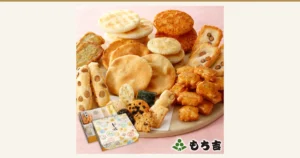 もち吉 お味見セット もちの縁 味まどかのアイキャッチ画像。ピンク色の和紙調の背景に、丸いおせんべいや豆入りのおかきなどの米菓を大きな丸い台に盛り、手前に絵柄入りの外箱を置いた商品写真。店舗が画像に入れた表示として右下に店舗ロゴ「もち吉」。