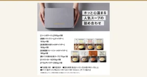 ニシキヤキッチン スープ8食ギフト（ギフト箱入り）のアイキャッチ。グレーの背景で両手に持ったグレーのギフト箱（ふたに金色の「NISHIKIYA KITCHEN」の文字）と、その下にレトルトスープのパウチ8袋（コーンポタージュ2袋が重なり、ほかに「Tomato Chowder」「Pumpkin Chowder」「Corn Chowder」「Tomato Minestrone」「Clam Chowder」と豚バラ大根の生姜スープの各1袋）が2段に並ぶ。画像内に店舗が画像に入れた表示として、「ホッと心温まる」「人気スープの」「詰め合わせ」「[コーンポタージュ]160g×2個」「[国産トマトクリームチャウダー]180g×1個」「[北海道産かぼちゃのチャウダー]180g×1個」「[北海道産スイートコーンのチャウダー]180g×1個」「[豚バラ大根の生姜スープ]170g×1個」「[ミネストローネ]180g×1個」「[クラムチャウダー]180g×1個」「■内容量/8個」「■常温保存」「■賞味期限/製造から12ヶ月(お届け時3ヶ月以上)」「■ギフト箱サイズ/幅235×奥行120×高さ165mm [ギフト箱(大)]」「※在庫状況によりセット内容が変更になる場合もございます。予めご了承ください。」の文字あり。
