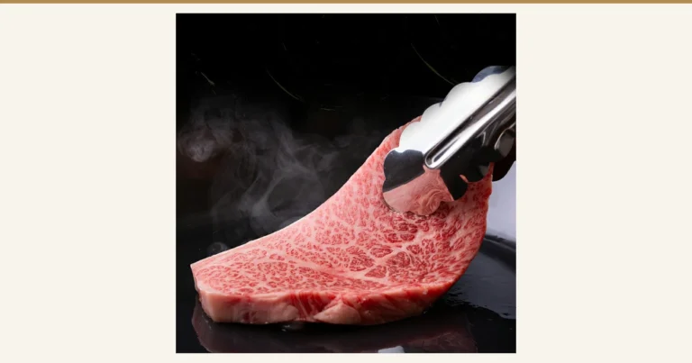 Featured image for A5 Japanese Black Beef Sirloin 600g (良肉問屋). Photo of a single marbled sirloin steak, steaming on a black iron griddle, being lifted with tongs. There is no text in the image.