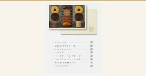 パティスリーキハチ 焼菓子ギフト 8種20個入の商品ページ画像。縁の淡い色の箱の中に、個包装のバームクーヘン（プレーンとショコラ）が左右の列に上下2つずつ、中央の列にマーブルケーク・パルミエ・フィナンシェ・マドレーヌが縦に並び、左右の列の下段には薄いクッキーが重なって収まる。右奥にクリーム色の外箱のふたが写り、下に内容の一覧がある。店舗が画像に入れた表示「フィナンシェ 2個」「はちみつマドレーヌ 1個」「マーブルケーク 1個」「パルミエ 2個」「バームクーヘン プレーン 2個」「バームクーヘン ショコラ 2個」「黒胡麻と黒糖クッキー 5個」「バニラクッキー 5個」、箱のふたに「KIHACHI」「HEART TO HEART May Pâtisserie KIHACHI sweets serve to enrich your moments with your precious ones.」