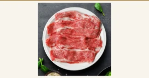 ミートたまや 黑毛和牛切り落とし（边角料切片）寿喜烧用1.2kg的商品照片：薄切牛肉摆放在白色圆盘上。盘边可见菠菜叶和芝麻，仅为摆设，不包含在商品中。