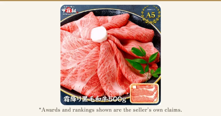 Product photo of Kouragumi domestic Kuroge Wagyu slices, 500g: thin slices of beef spread in a black bowl with a green leaf garnish, and a small photo of sliced beef in a tray at the lower right. Text the shop placed in the image: the shop logo "越前かに職人 甲羅組 DENSHOKU", a laurel badge reading "最高級ランク A5", and "霜降り黒毛和牛500g". Below the photo: "*Awards and rankings shown are the seller's own claims."