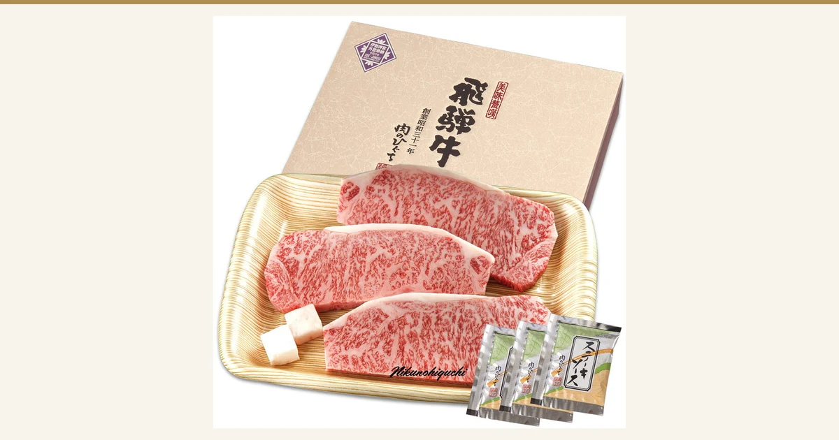 飛騨牛 サーロインステーキ 計500g（165g位×3枚）の記事アイキャッチ。飛騨牛 サーロインステーキ 計500g（165g位×3枚）の商品写真。木目調のトレイに生のサーロインステーキ3枚と付属のステーキソース3袋がのり、後ろに化粧箱が立てかけられている。画像内の文字は店舗が入れた表示で、箱に「美味歓饌」「飛騨牛」「創業昭和三十一年 肉のひぐち」の文字と小さな奉納のマーク、写真の下部に「Nikunohiguchi」の署名風の文字がある。