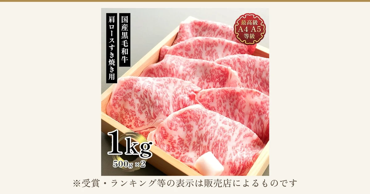 木の箱に霜降りの牛肩ロースのスライスが並んだ、肉処 三代目本多 国産黒毛和牛 メガ盛肩ロースすき焼きスライス 1kgの商品写真。店舗が画像に入れた表示「国産黒毛和牛」「肩ロースすき焼き用」「最高級 A4 A5 等級」「1kg 500g×2」。写真の下に「※受賞・ランキング等の表示は販売店によるものです」