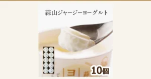 Product photo of Hiruzen Jersey Yogurt showing a spoon scooping up yogurt and a box with 10 white-lidded cups lined up in 2 rows. Text the shop placed in the image: “蒜山ジャージーヨーグルト” (Hiruzen Jersey Yogurt), “10個” (10 cups)