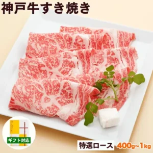 白い角皿に重ねて広げた神戸牛すき焼き肉(特選ロース)の薄切り肉の商品写真。右にクレソンと白い脂の小片が添えられ、左下に黄色い包装紙の化粧箱の小さな写真が入る(神戸牛専門店 辰屋 神戸牛 すき焼き肉 特選ロース)。店舗が画像に入れた表示「神戸牛すき焼き」「ギフト対応」「特選ロース」「400g〜1kg」