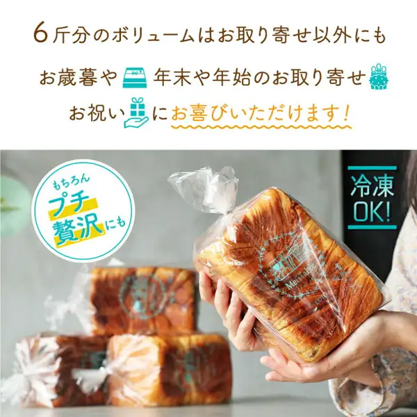 店のロゴ入りの透明な袋に入ったデニッシュ食パン1本を手元だけが写る両手で持った様子と、背景に袋入りの食パンが積まれた様子を写した、メイズテーブル デニッシュ食パンの商品画像。店舗が画像に入れた表示：「6斤分のボリュームはお取り寄せ以外にも」「お歳暮や 年末や年始のお取り寄せ お祝いにお喜びいただけます！」「もちろんプチ贅沢にも」「冷凍OK!」