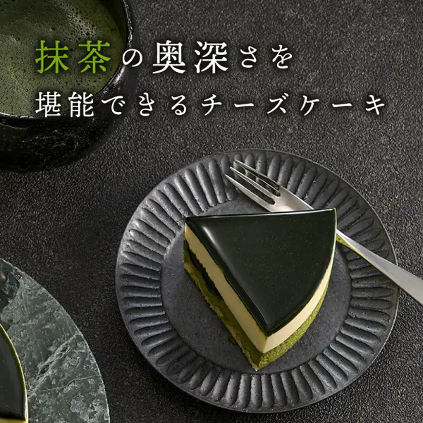 黒い皿にのせた京都ヴェネト 宇治抹茶生チーズケーキ ジェミニ 4号の切り分けた一切れを写した商品写真。店舗が画像に入れた表示「抹茶の奥深さを堪能できるチーズケーキ」