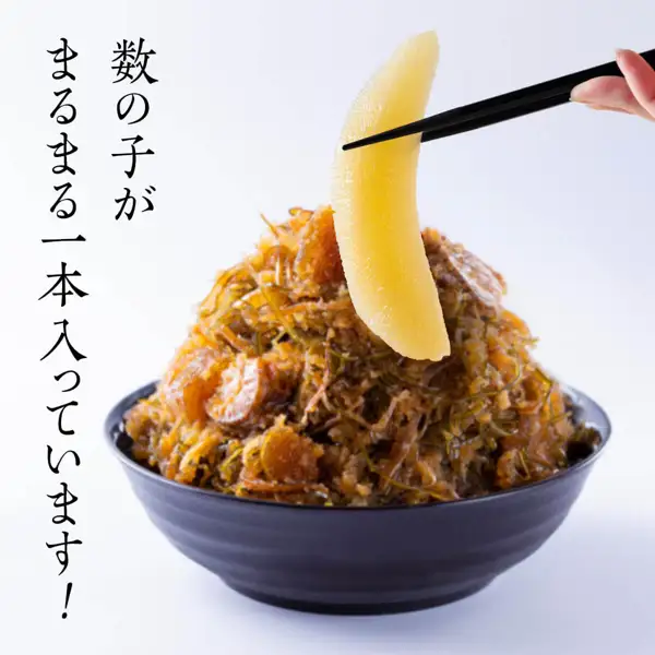 Plating-example photo of Shikabe Matsumae-zuke heaped in a black bowl, with one whole kazunoko lifted by chopsticks (Shikabe Matsumae-zuke with kazunoko, scallop and kelp). The bowl and chopsticks are not included. Text the seller placed in the image: “数の子がまるまる一本入っています!”