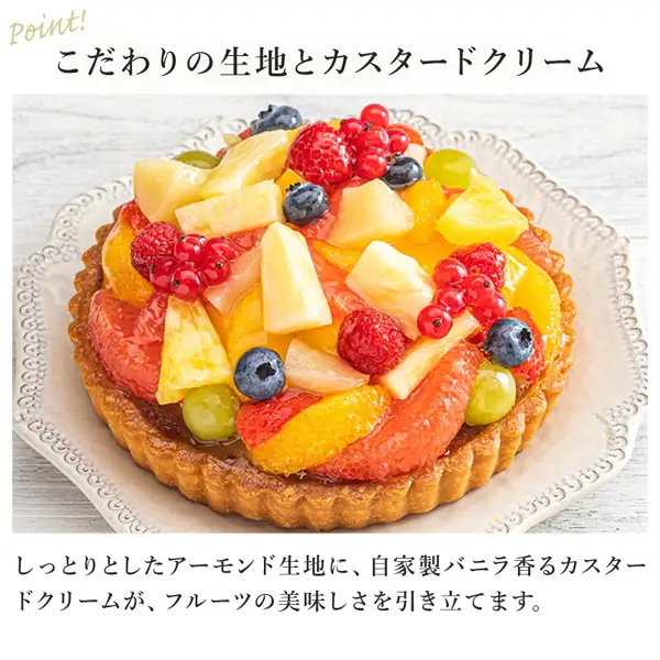 皿にのせたフルーツタルト（ラ・メゾン フルーツタルト ホール 直径16cm）の店舗掲載写真。パインアップル・オレンジ・ピンクグレープフルーツ・ぶどう・ラズベリー・赤すぐり・ブルーベリーがのっている。画像内に店舗が画像に入れた表示として、「Point!」「こだわりの生地とカスタードクリーム」「しっとりとしたアーモンド生地に、自家製バニラ香るカスタードクリームが、フルーツの美味しさを引き立てます。」の文字あり。