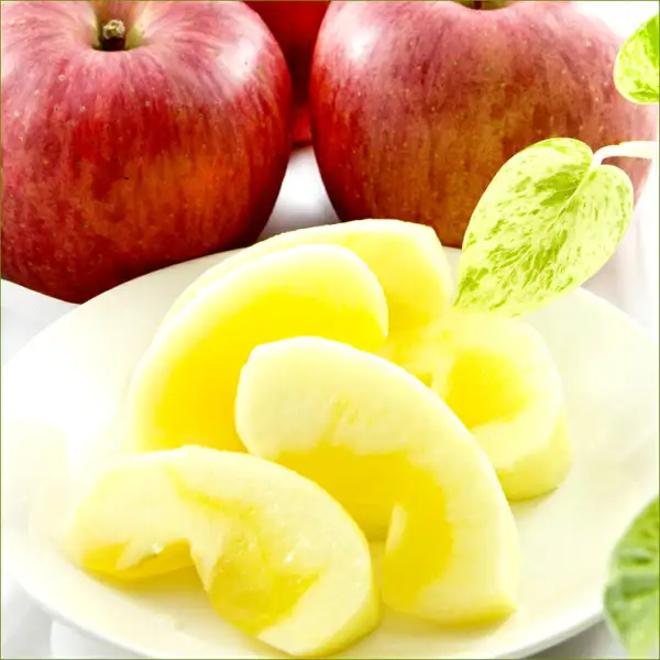 Photo of sliced Sun Fuji apple on a plate (Winter Fruit Assortment 3kg from 竹城青果). Two red apples sit behind, and slices with translucent yellow watercore lie on the plate in front