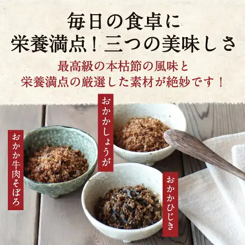 Product photo of the Furikake Set of 4, Additive-Free (Suzuki Katsuobushi-ten 鈴木鰹節店): on a wooden table, three bowls hold the furikake — おかか牛肉そぼろ in a greenish bowl on the left, おかかしょうが in a white bowl at the back, and おかかひじき in a white bowl in front — with a wooden spoon and a white cloth on the right. Text the shop placed in the image reads two lines of the shop’s promotional copy and “おかか牛肉そぼろ”, “おかかしょうが” and “おかかひじき”.