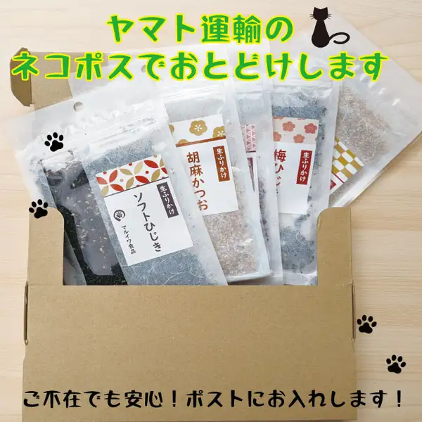 段ボール箱に、「ソフトひじき」「胡麻かつお」「梅ひじ」(一部が隠れている)などのラベルが付いた透明な小袋を立てて詰めた商品写真(マルイワ食品 ふりかけ 5種類セット 個包装)。箱は木の台の上に置かれ、黒猫と肉球のイラストが添えられています。店舗が画像に入れた表示として「ヤマト運輸のネコポスでおとどけします」「ご不在でも安心!ポストにお入れします!」の文字。袋のラベルに「生ふりかけ」「マルイワ食品」の印字