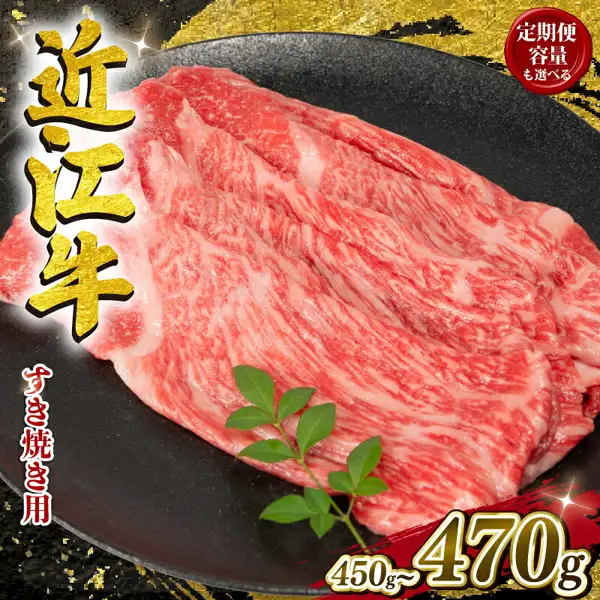 黒い皿に広がる近江牛のすき焼き用の薄切り肉に緑の葉を添えた商品写真（配送月が選べる 近江牛 すき焼き）。店舗が画像に入れた表示「定期便 容量も選べる」「近江牛」「すき焼き用」「450g~470g」