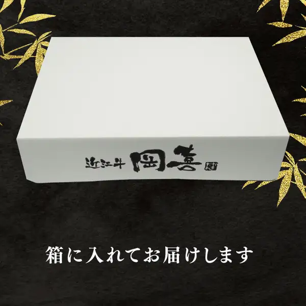 Product photo of a plain white box with the logo “近江牛 岡喜” (Omi beef Okiki) printed in black, a gift box in which the meat is delivered (配送月が選べる 近江牛 すき焼き [Omi beef sukiyaki with a choice of delivery month]). Text the shop placed in the image: “箱に入れてお届けします” (delivered in a box)