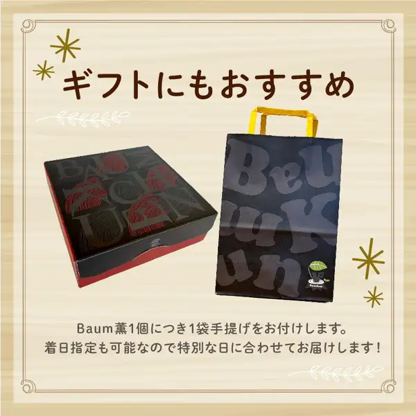 Product page image for the furusato nozei gift “ばあむくん かため” (Baamukun Katame). A gift box in black with a red pattern and a black paper handbag are shown side by side, with the words “ギフトにもおすすめ” above them. Text the shop placed in the image: “ギフトにもおすすめ” (also recommended as a gift), “Baum薫1個につき1袋手提げをお付けします。” (one handbag is included per Baum薫), “着日指定も可能なので特別な日に合わせてお届けします！” (a delivery date can also be specified, so it can arrive to suit a special day!).